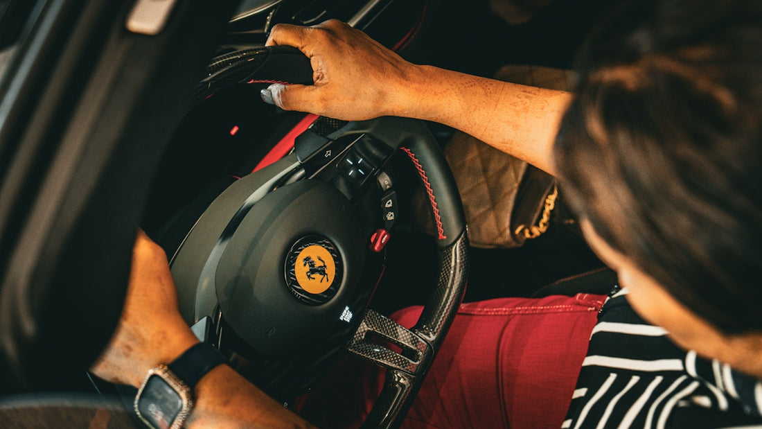 Person reaches for the steering wheel in a ferrari