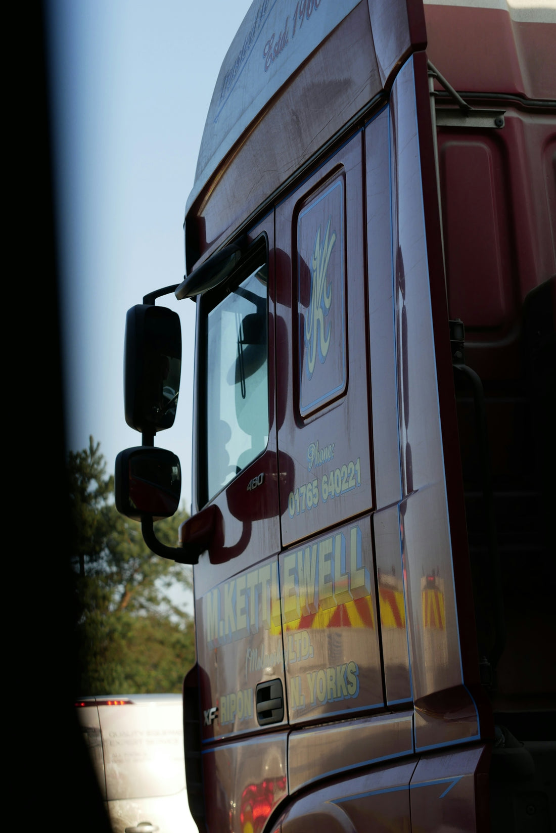 Maroon truck with reflective markings and logo.